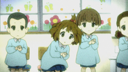 Yui cheerfully playing her castanets in kindergarten.