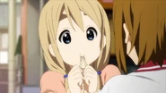 Tsumugi stuffs neri-ame into her mouth.