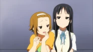 Ritsu teasing Mio for wearing her uniform.