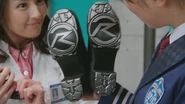 Rinna handing Kiriko the Rear Cowl Boots