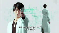 Taiga replaces Emu's spot, holding his Gashat outward.