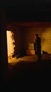 An image of a man (not Ravi) in front of a hole in the wall.
