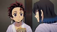 Tanjiro offering his food to Inosuke.