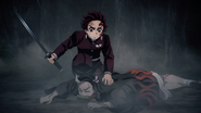 Tanjiro checks on Nezuko's injuries.