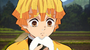 Zenitsu eating the onigiri given to him by Tanjiro
