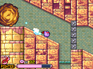 Kirby dashes from a massive boulder in the ruins.