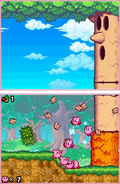 Varios Kirby luchando contra Whispy Woods.