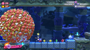 Kirby runs from a gigantic sphere of Waddle Dees.