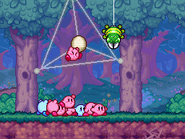 A green Spideroo pursues a Kirby.