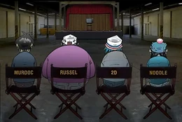 The Gorillaz sitting on the chairs waiting for the video to start.