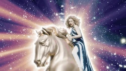 Kylie mounted on top of a golden horse sculpture, wearing a Halston-inspired dress worn by Marisa Berensons
