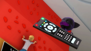 Plagg holding a remote control to Adrien's TV.