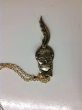 Gold necklace with a skull with Gaga's features.