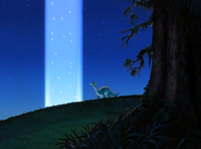 Littlefoot gazes at a pillar of light where the two Rainbow Faces once stood