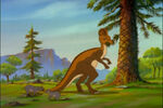 A Corythosaurus, feeding on leaves from a tree, in the opening scene of the film. Two early mammals feed on grass beside the Corythosaurus.