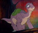 Littlefoot, carrying the treestar from his mother on his back.