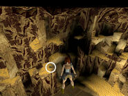 If you use the Look button and rotate Lara's vision, you can catch a glimpse of a dark object against the lighter background of the sandy ledges along the cave wall. This is secret #1, the UZIS, floating on an invisible platform. The guns are circled in these screenshots. Carefully position Lara at this corner squarely facing the Uzis below. Use the Look button to make sure she's facing the right way. NOTE: The screenshot above was taken with the camera shifted upward and to the left a bit so you can see both the corner where Lara is standing and the guns, but she's in the correct spot.)