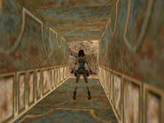 Return to the hallway at the bottom of the slope. Step on the one floor tile without the gold pattern on it. Lara is standing on it in the screenshot above.