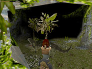 Follow this passageway, which is roughly U-shaped. About halfway in you'll encounter another raptor. Kill it and keep going to a second opening higher in the valley wall (shown above, as well as in the screenshot below, where it is labeled "cave mouth"). Then just wait and blast the T. Rex as he stomps by.