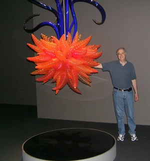 An art exhibit displaying a Gw'otesht (a large collection of Gw'oth) with their creator Edward M. Lerner.