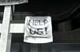 Survivor sign: "Help us!"