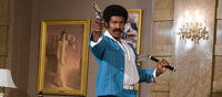 Black Dynamite using a gun and a nunchuck.