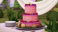 Le gâteau de mariage est rose avec des cœurs...