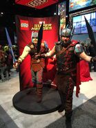 A fan wearing a Gladiator Thor costume with the LEGO brick-built Thor.