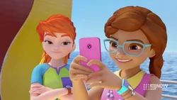 Olivia taking a social media photo of Andrea playing skeeball.