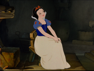 Blanche-Neige assise dans la chaumière.