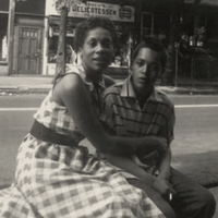 A butch/femme couple photographed in front of their apartment in the 1950s