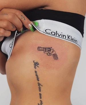The gun tattoo on Jesy's left side