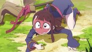 Akko looking up at what knocked her off her Frog Leg-ged broom