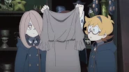 Akko holding up an old dress that disintegrates on her hands, much to her dismay