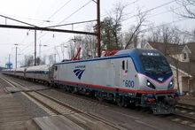 An electric Amtrak train led by an  locomotive running through Maryland on the Northeast Corridor
