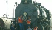 The workers are trying to put the logo from Union Pacific 'Big Boy' No. 4014 on the steam locomotive