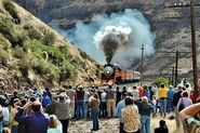 The locomotive doing a photo runby in the mountains.