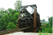 587 hauling a passenger train while crossing a bridge.