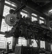 Engine #3733 is being lifted by a crane to be carried to another part of the Santa Fe shop for wheeling in 1943.