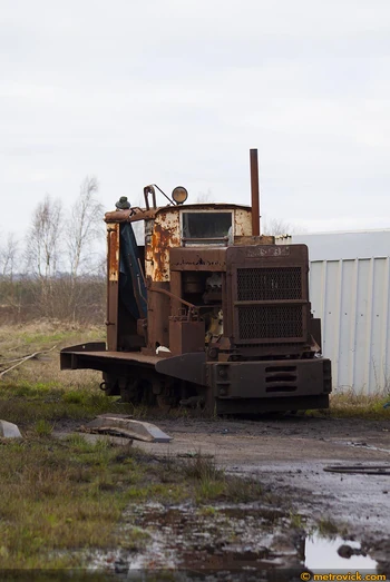 An old forlorn looking ruston sitting at a depot.