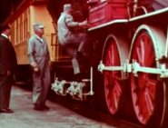 The engineer and fireman climbing in the locomotive.