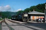 No. 587 is being towed by a Norfolk Southern EMD GP38-2 diesel locomotive.