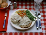 In the episode "Father Knows Least", the logo's plate contains chicken fried steak with mashed potatoes, green beans, and mixed vegetables.