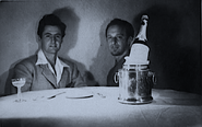 Bob Clampett and Michael Sasanoff seated at a table with a bottle of carrot juice, photographed for animation reference.