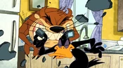 As Daffy tries to get the phone, Taz bites it.