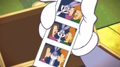 Bugs looking at a photo of himself and two ladies at the paparazzi photo booth.