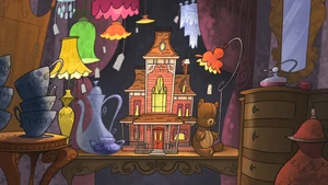 The antique house, next to other antiques on a table.