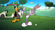 Daffy waits for Bugs to hit the golf ball.