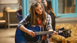 Hannah practises on her guitar.