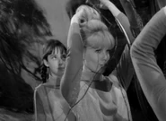 Judy admires herself in the mirror white Penny thinks she's silly.